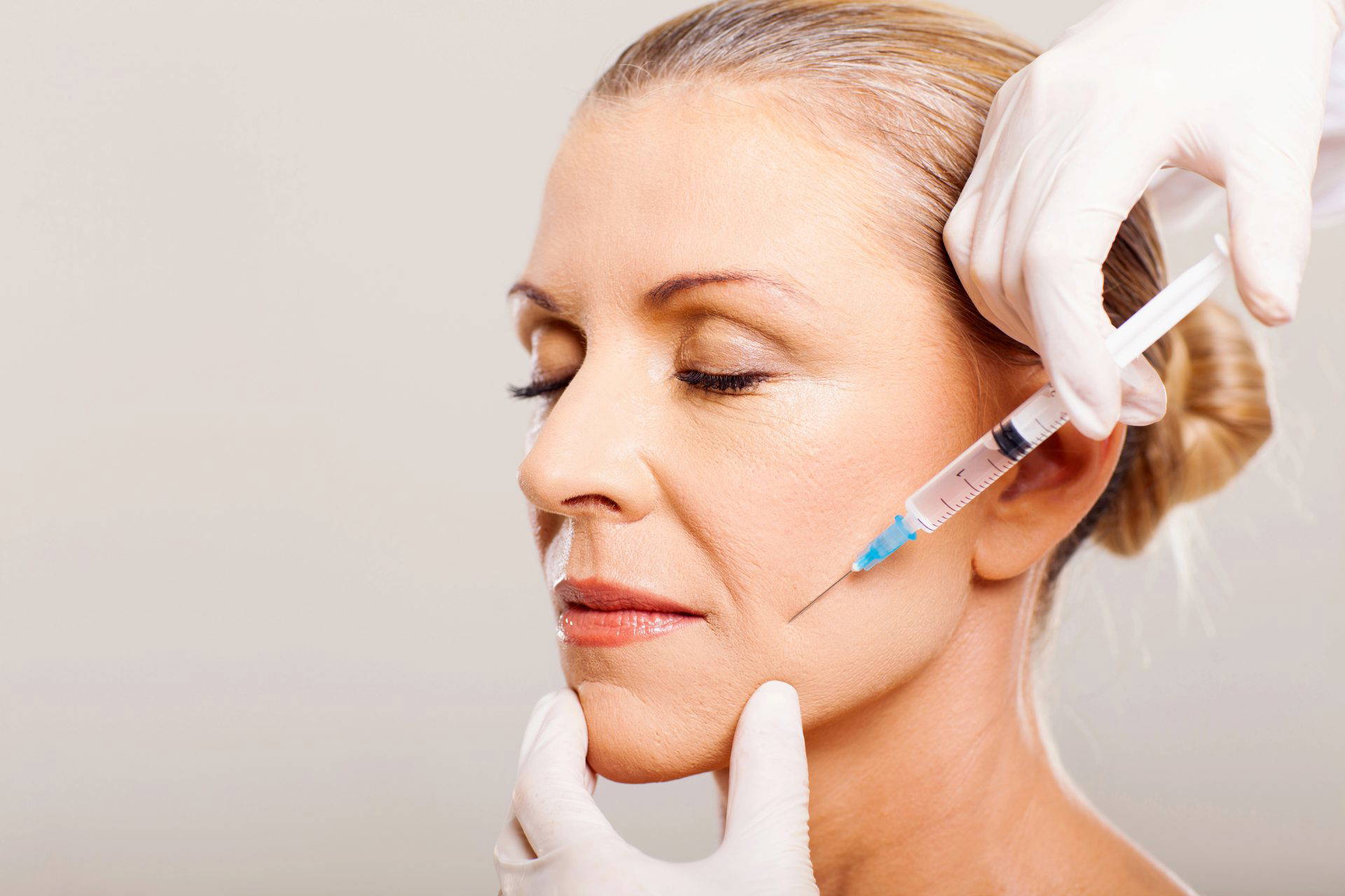 Woman relaxing while receiving a facial aesthetics injection treatment