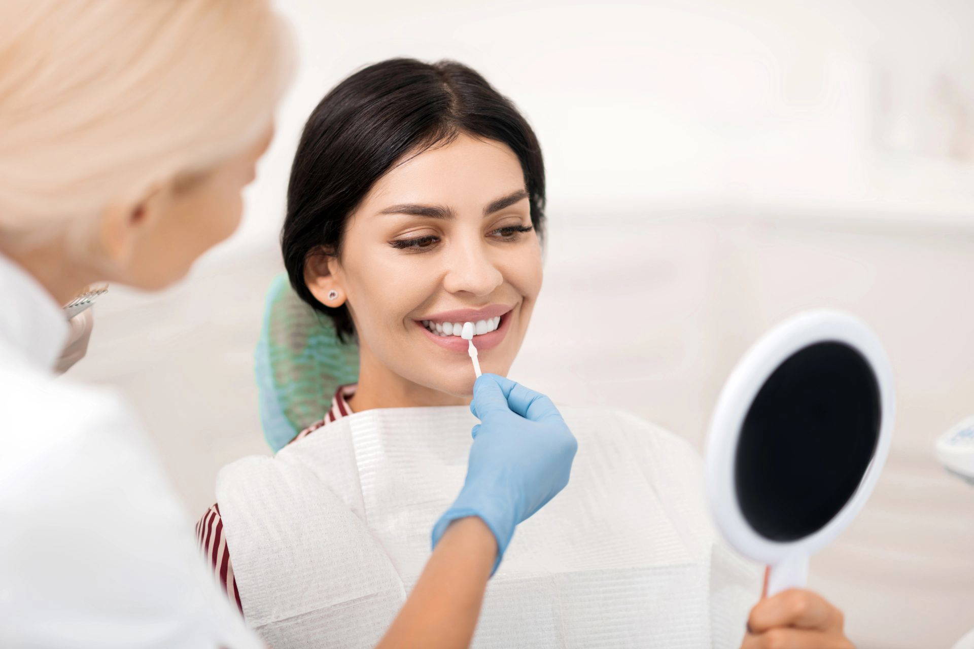 Woman smiling confidently with bright, perfectly shaped dental veneers