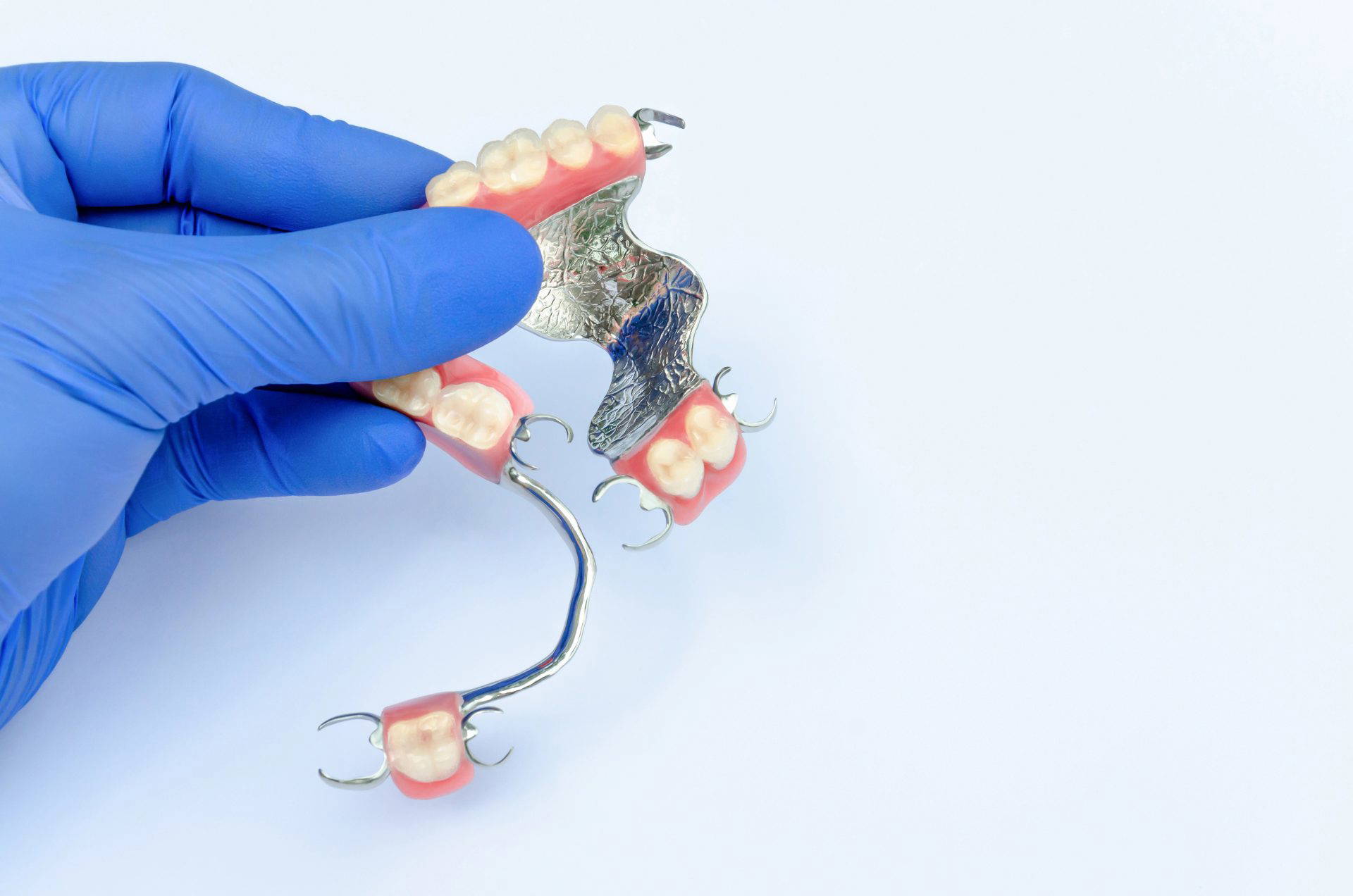 Dentist fitting a set of dentures with dental tools