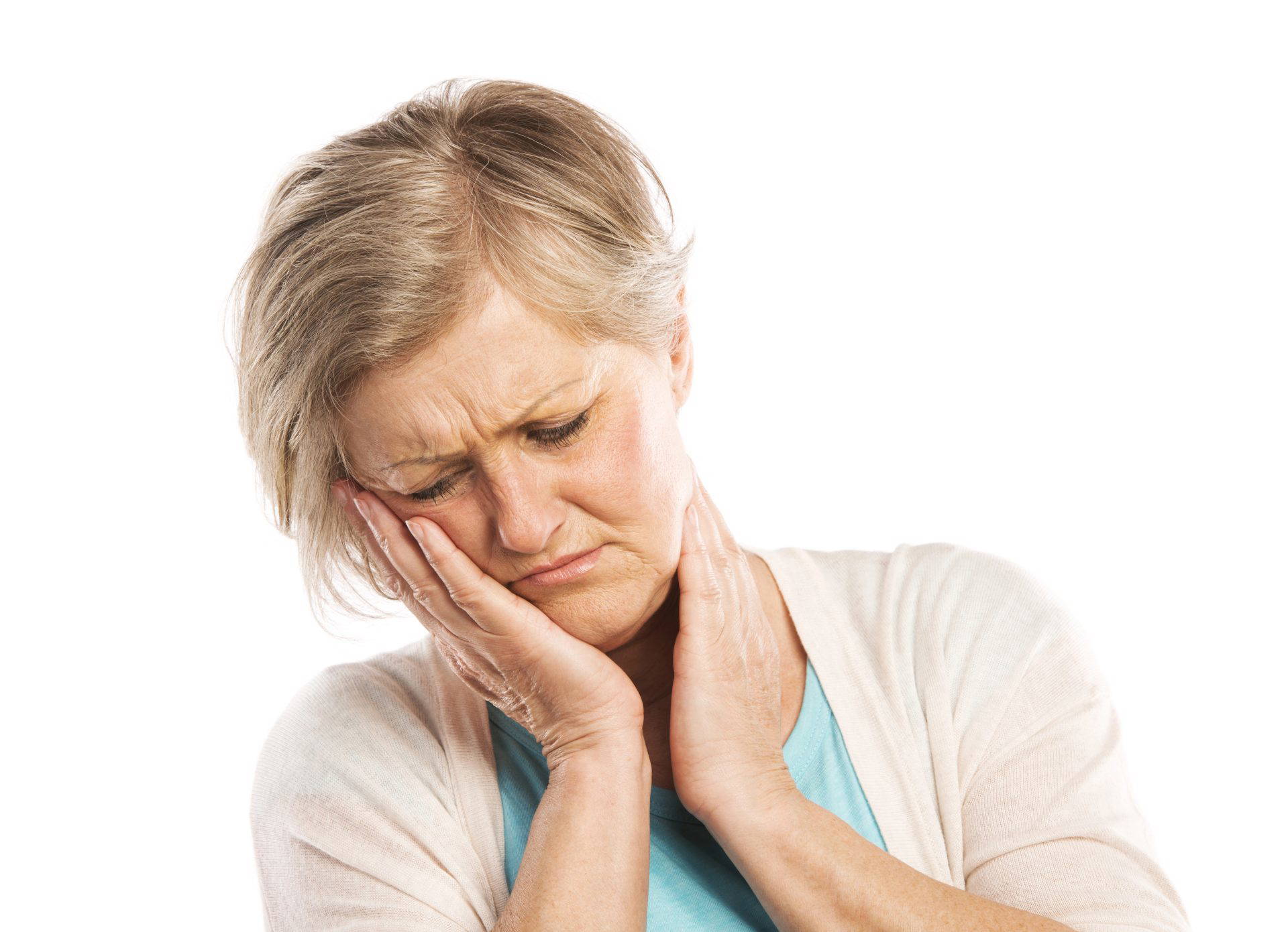 Woman grimacing and holding her cheek due to tooth pain