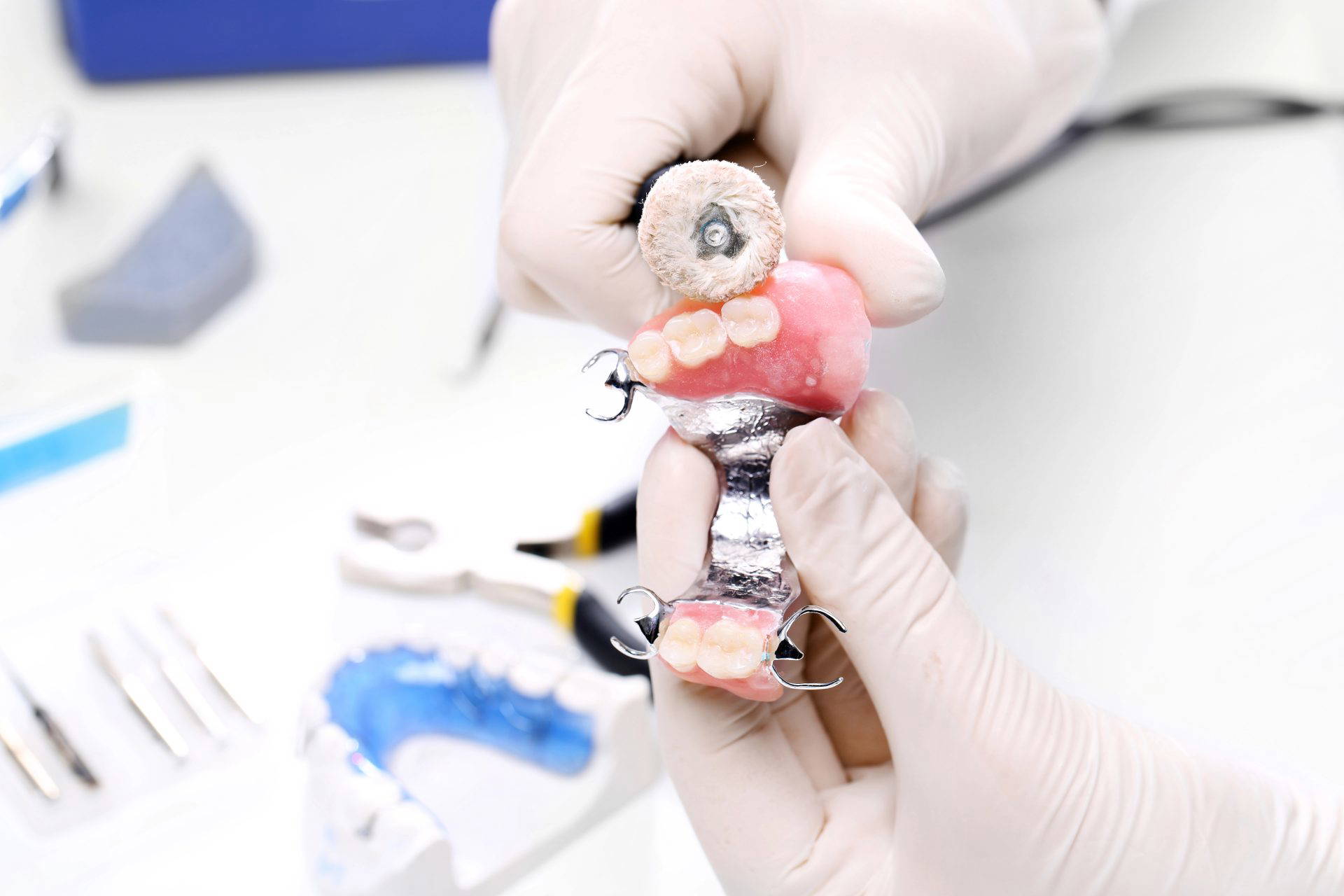 Dentist carefully adjusting and fitting dentures for a patient