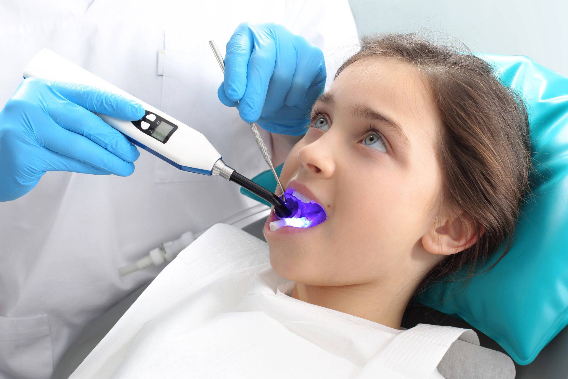 Dentist using a tool to prepare a tooth for a filling