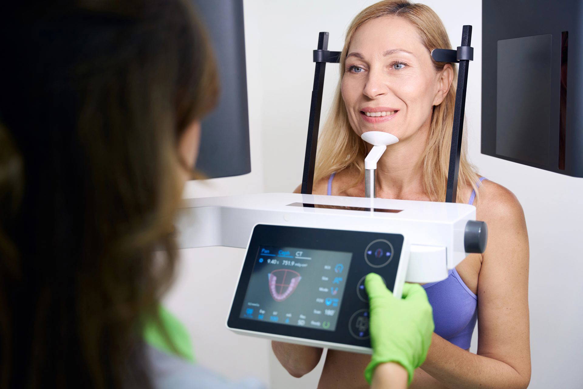 Dentist in mask discussing dental implant options with a patient