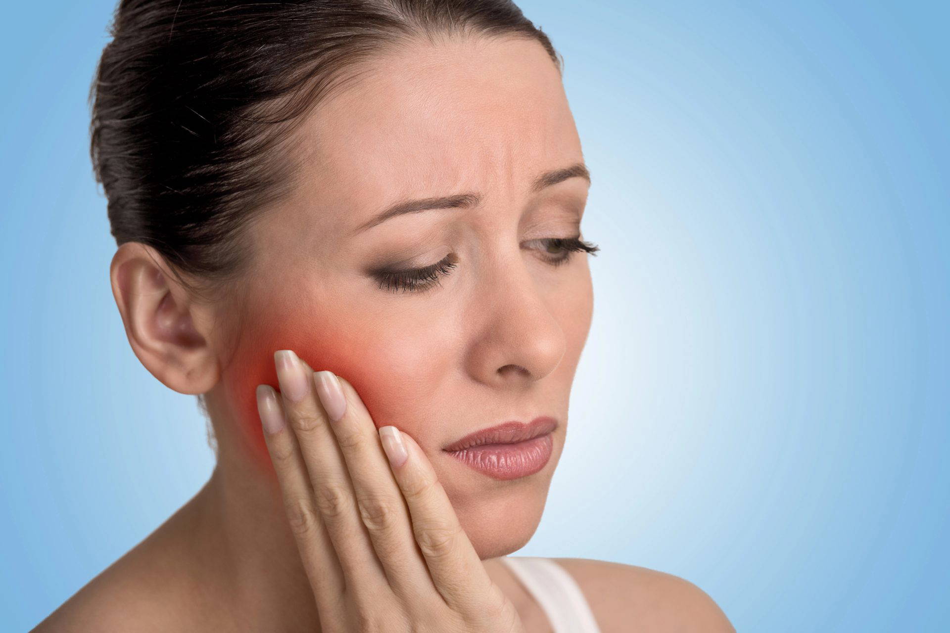 Woman holding the side of his face, suffering from dental pain